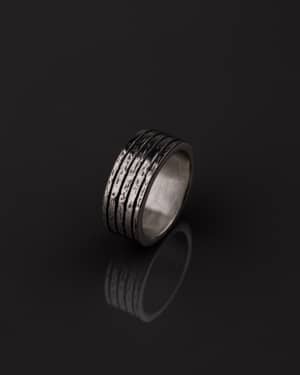 Anillo Valurys para hombre con Su estructura segmentada y la textura robusta de las bandas le otorgan un carácter fuerte, evocando poder y solidez.