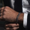 Pulseras de acero quirúrgico Valurys para hombre, modelos Cadena Fina y Cordón, combinadas para un look elegante.