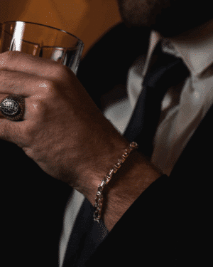 Pulsera trenzada de acero quirúrgico para hombre sobre fondo negro.