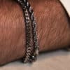Pulseras de acero quirúrgico Valurys para hombre, modelos Cadena Fina y Cordón, combinadas para un look elegante.